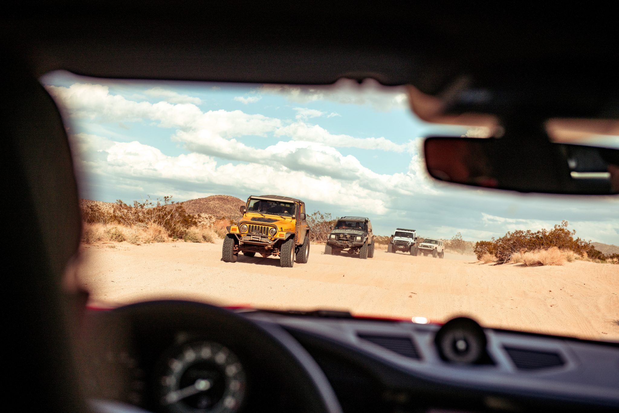 Jeep Wrangler en Cherokee gezien vanuit Porsche 911 Turbo S in woestijn