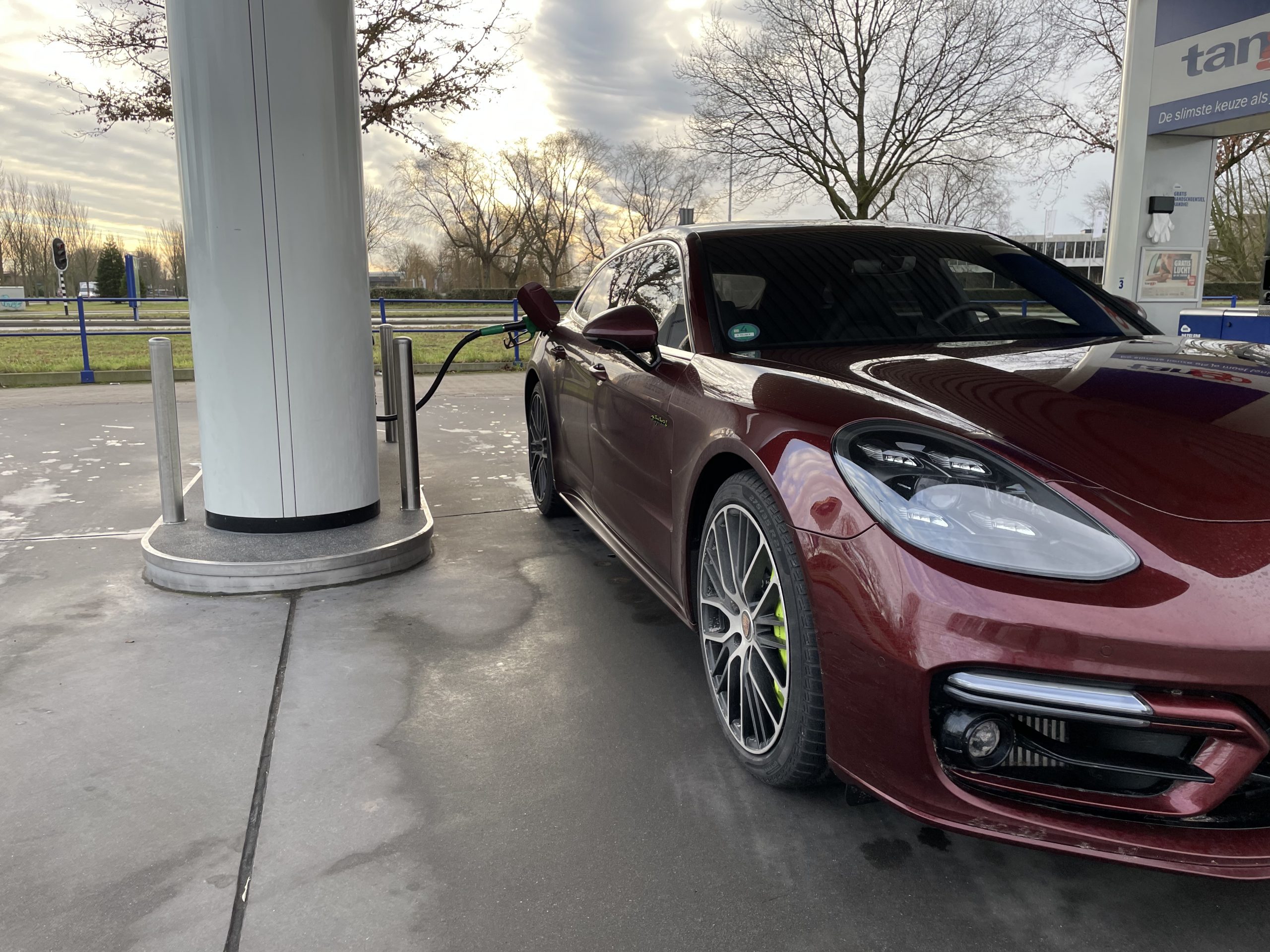 Porsche Panamera Sport Turismo Turbo S E-Hybrid tanken bij het tankstation. Benzine, geen diesel